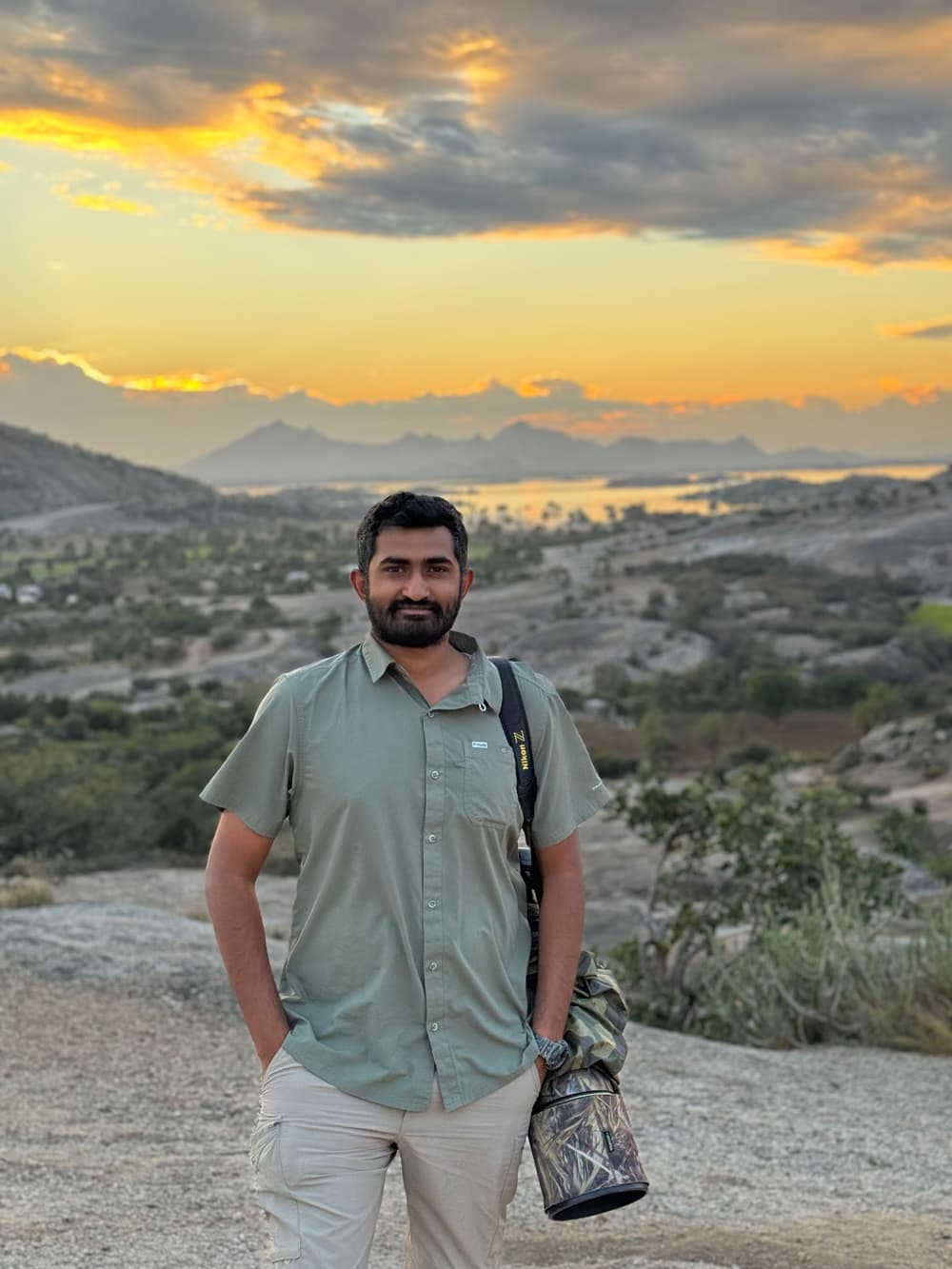 Gaurav Ramnarayanan with his camera in a granite landscape at sunset